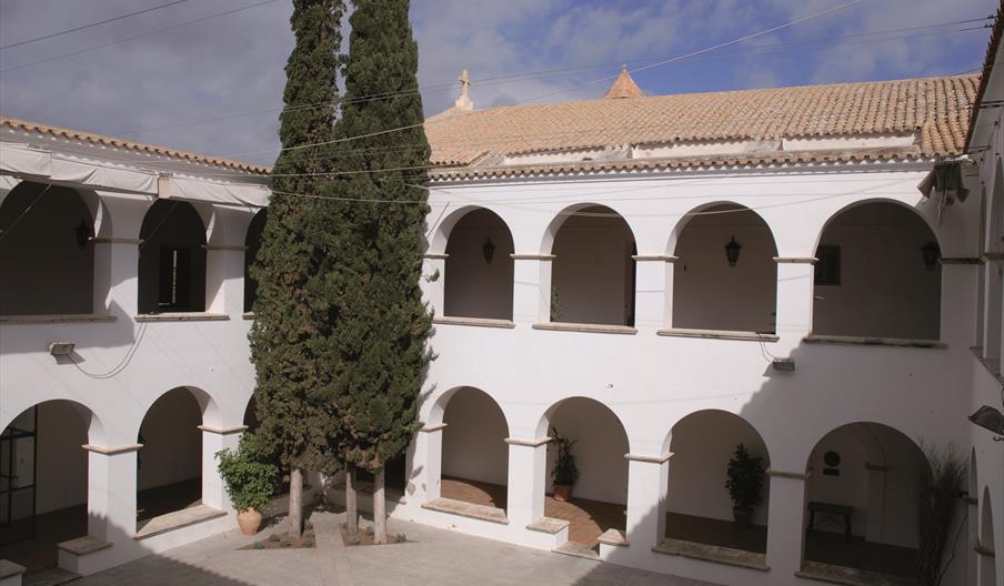 Patio interior del Claustro del Convento de los Dominicos, un espacio histórico de arquitectura religiosa con galerías porticadas de arcos blancos dis
