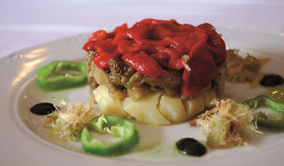 Ensalada payesa, plato tradicional de la gastronomía ibicenca elaborado con patata, pescado seco, pimientos y otros ingredientes locales, presentado c