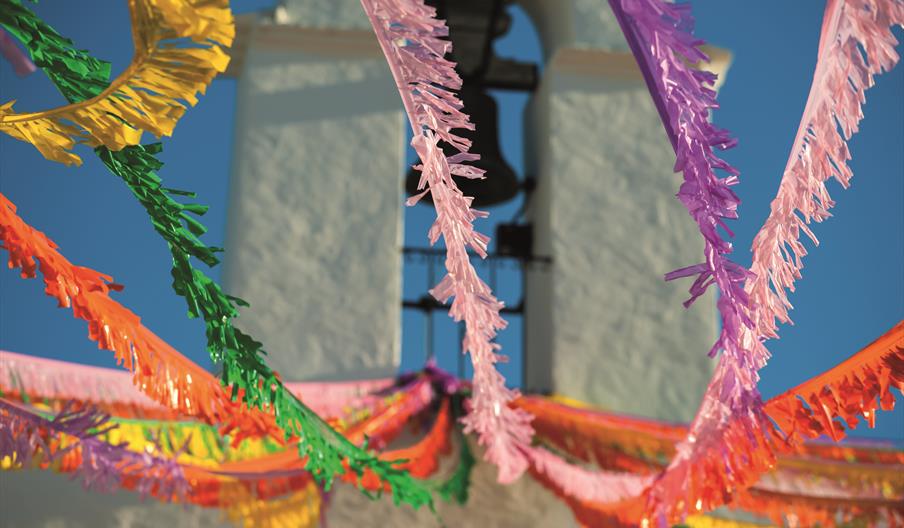 Fiesta Sant Agustí en Sant Josep de sa Talaia. Se ven cintas de colores que cuelgan del campanario de la iglesia.