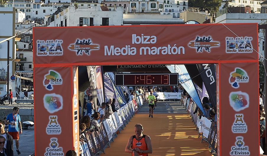 Varios atletas entrando en la meta de la Ibiza Media Maratón, con Dalt Vila al fondo.