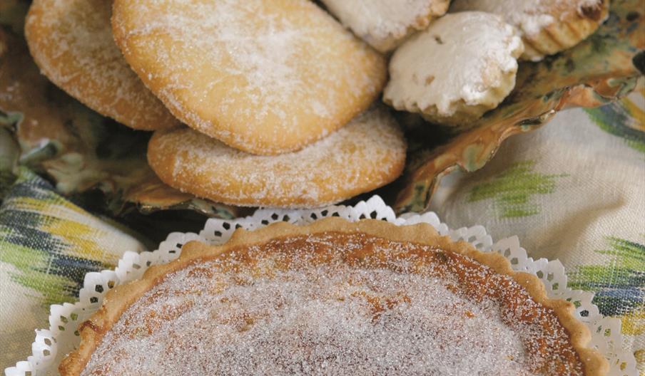 Bandeja con una selección de dulces tradicionales ibicencos, entre ellos magdalenas payesas, galletas y tartas caseras espolvoreadas con azúcar, elabo