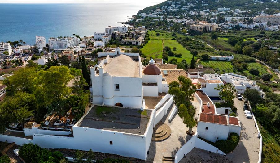 Vista aérea de la iglesia de Santa Eulària des Riu en el Puig de Missa, conjunto fortificado de arquitectura tradicional ibicenca con vistas al mar y