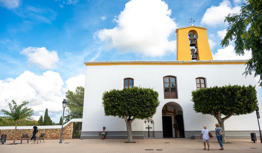 Iglesia de Santa Gertrudis de Fruitera, de arquitectura tradicional ibicenca con campanario amarillo, situada en una plaza del centro de Ibiza bajo un