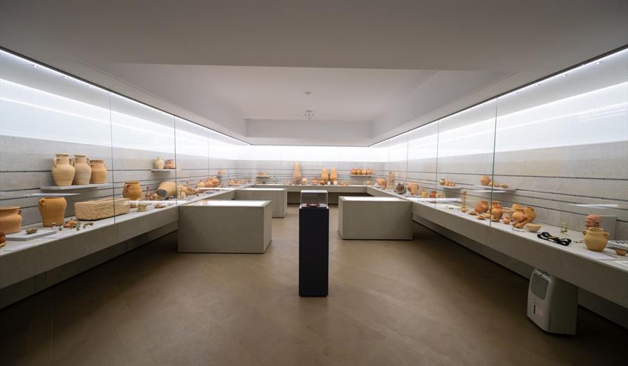 Sala expositiva del Museo Monográfico y Necrópolis de Puig des Molins en Ibiza, con vitrinas de piezas arqueológicas fenicias y púnicas en un espacio