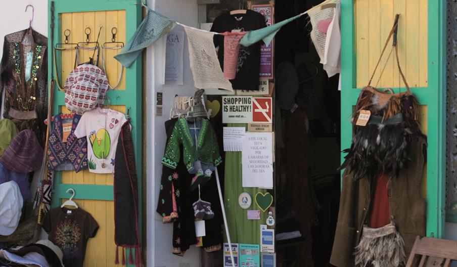 Puesto de artesanía y moda local en el Mercado de Artesanía de Santa Gertrudis, con prendas, complementos y creaciones hechas a mano en un ambiente tr